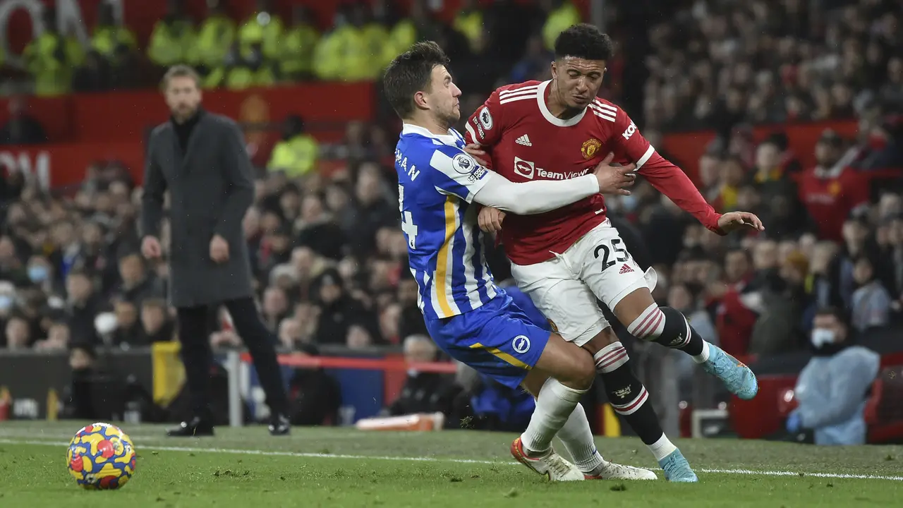 Penyerang Manchester United (MU) Jadon Sancho berebut bola dengan bek Brighton & Hove Albion Joel Veltman pada laga pekan ke-18 Liga Inggris di Old Trafford, Rabu dini hari WIB (16/2/2022). MU menang dengan skor meyakinkan 2-0.