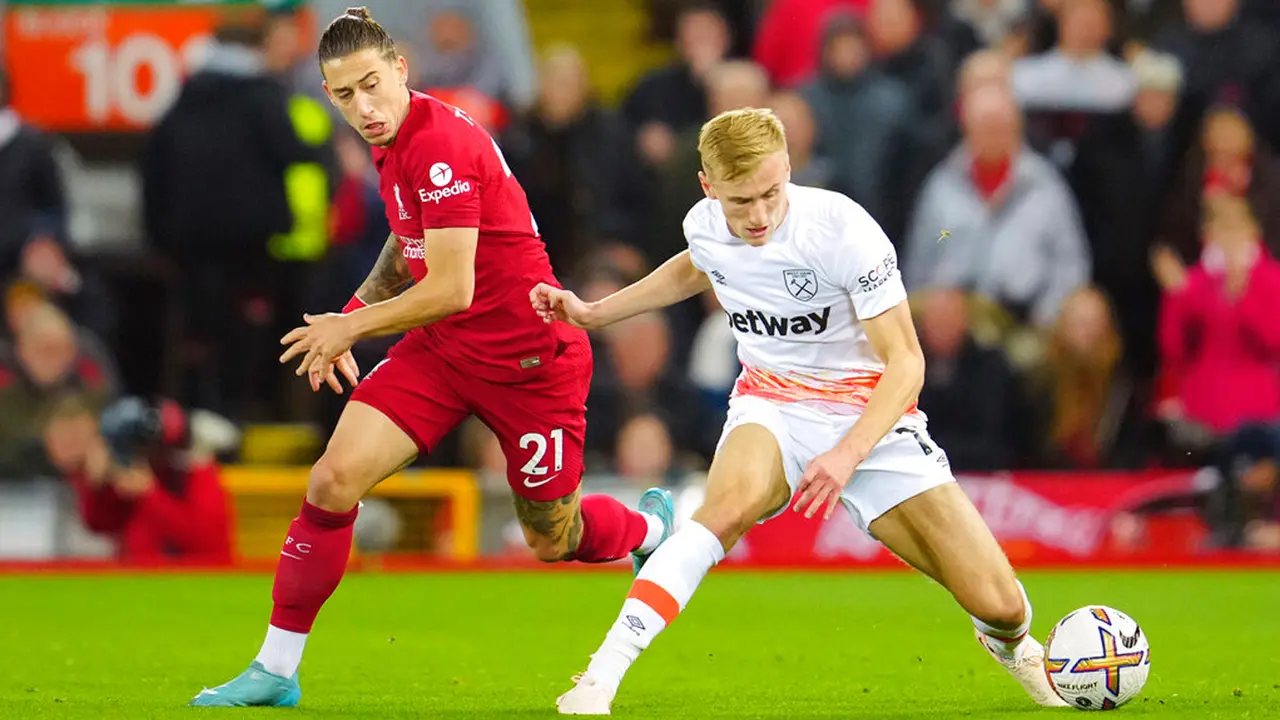 Pemain West Ham United Flynn Downes (kanan) berebut bola dengan pemain Liverpool Kostas Tsimikas pada pertandingan sepak bola Liga Inggris di Stadion Anfield, Liverpool, Inggris, 19 Oktober 2022.