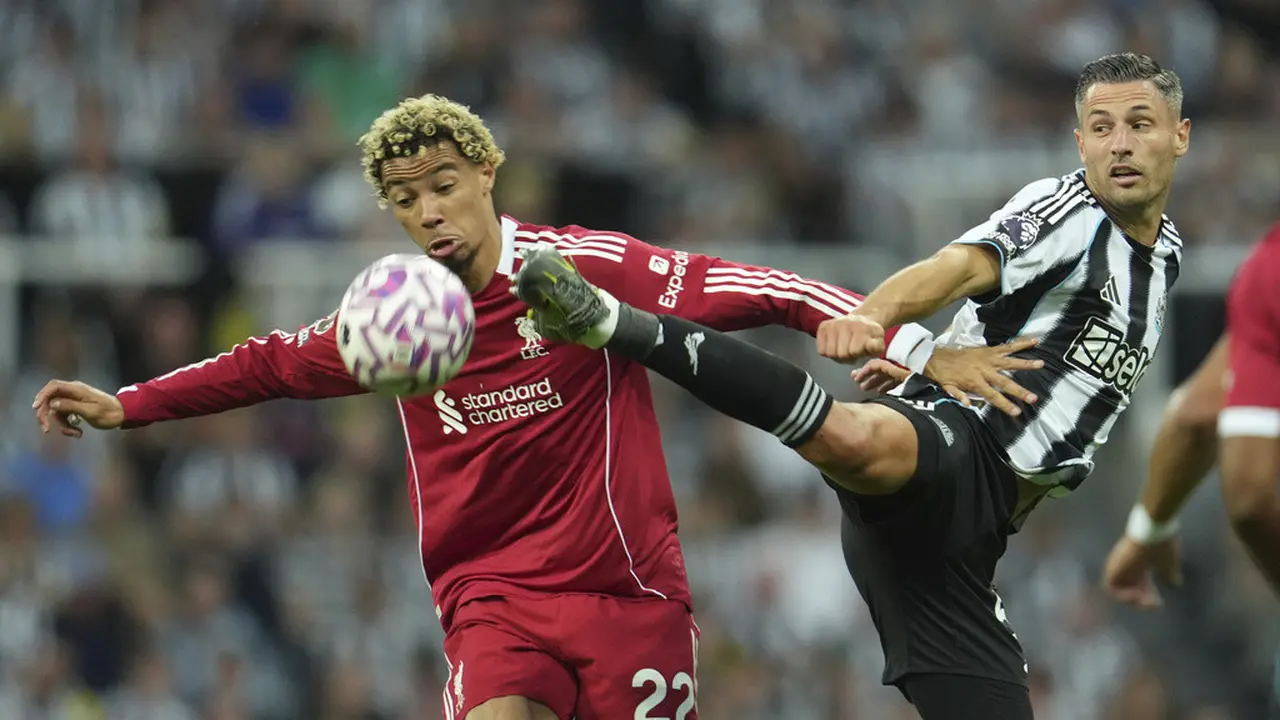 Pemain Liverpool, Hugo Ekitike, berebut bola dengan pemain Newcastle United, Fabian Schaer. pada pekan kedua Liga Inggris di St James’ Park, Selasa (26/8/2025) dini hari WIB. 