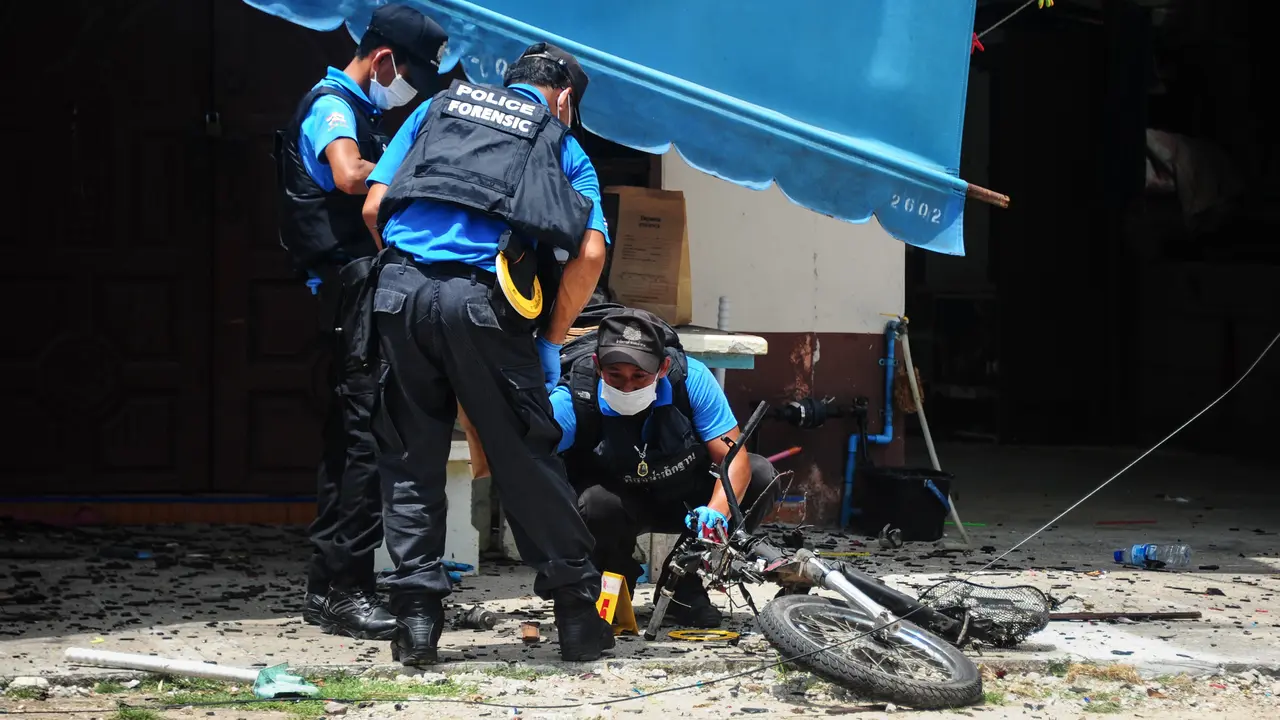 Polisi memeriksa lokasi ledakan bom motor di luar sebuah sekolah di distrik Tak Bai, Thailand, Selasa (6/9). Bom yang disembunyikan di tangki bahan bakar sepeda motor meledak saat para siswa dan guru memasuki halaman sekolah.